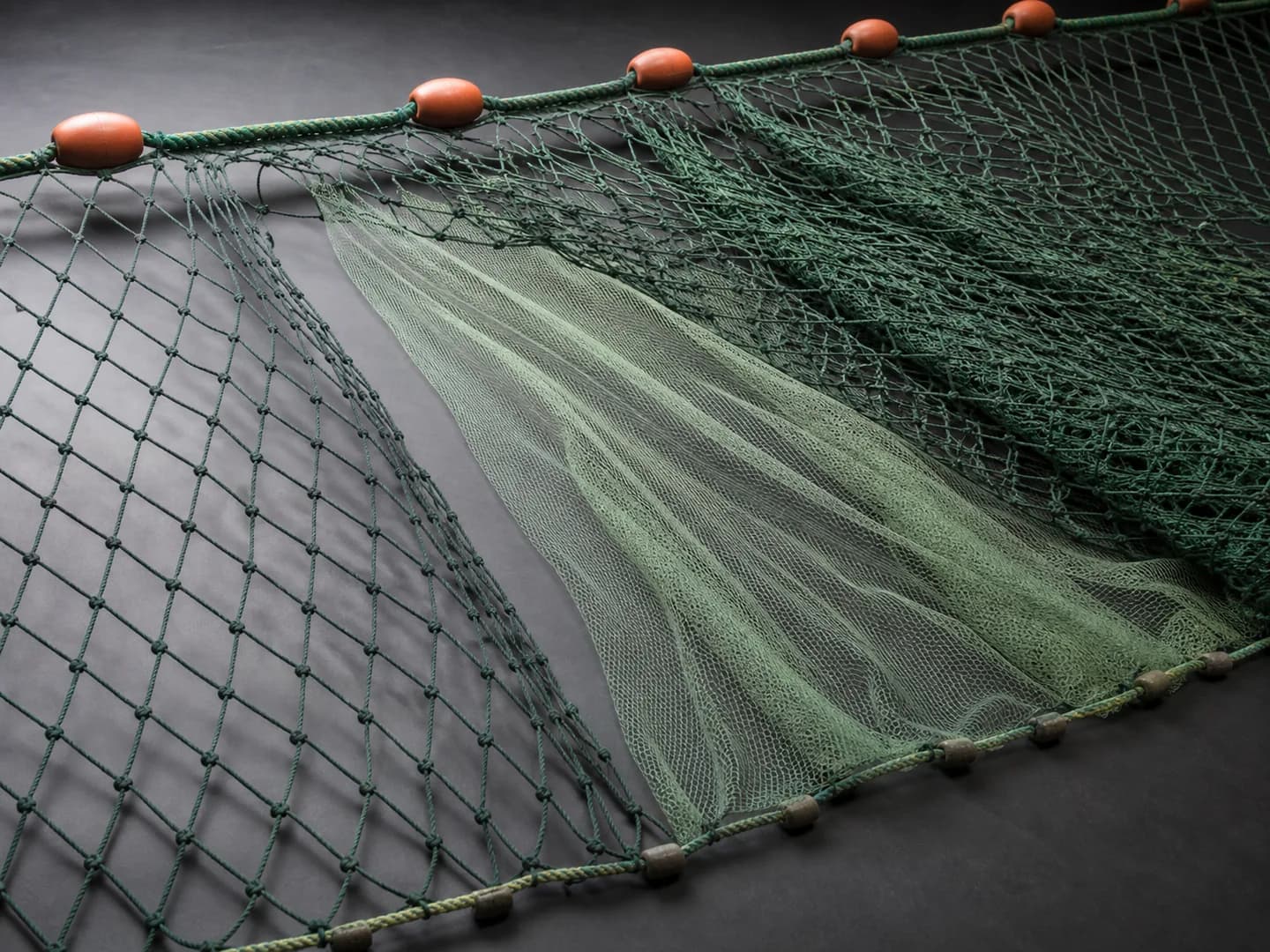 Layered trammel fishing net with floats and weighted line